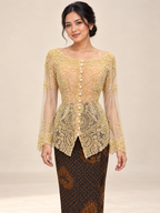 Kebaya Kendedes in pale yellow with intricate beadwork, styled with a dark brown batik skirt on a model against an ivory studio background.